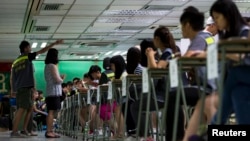 A guide leads a woman to a polling station during a civil referendum held by Occupy Central in Hong Kong, June 29, 2014. 