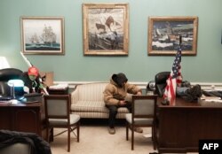 Supporters of U.S. President Donald Trump sit inside the office of U.S. Speaker of the House Nancy Pelosi as they protest inside the U.S. Capitol in Washington, Jan. 6, 2021.