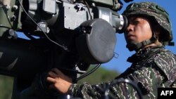 这张最近由台湾国防部发布的未注明日期的照片显示，一名士兵在台湾南部屏东县的演习中操作美国制造的TOW-2A反装甲导弹系统。（于2020年6月5日）