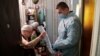 An elderly woman casts a ballot during municipal elections in Tomsk, Russia, Sept. 13, 2020.