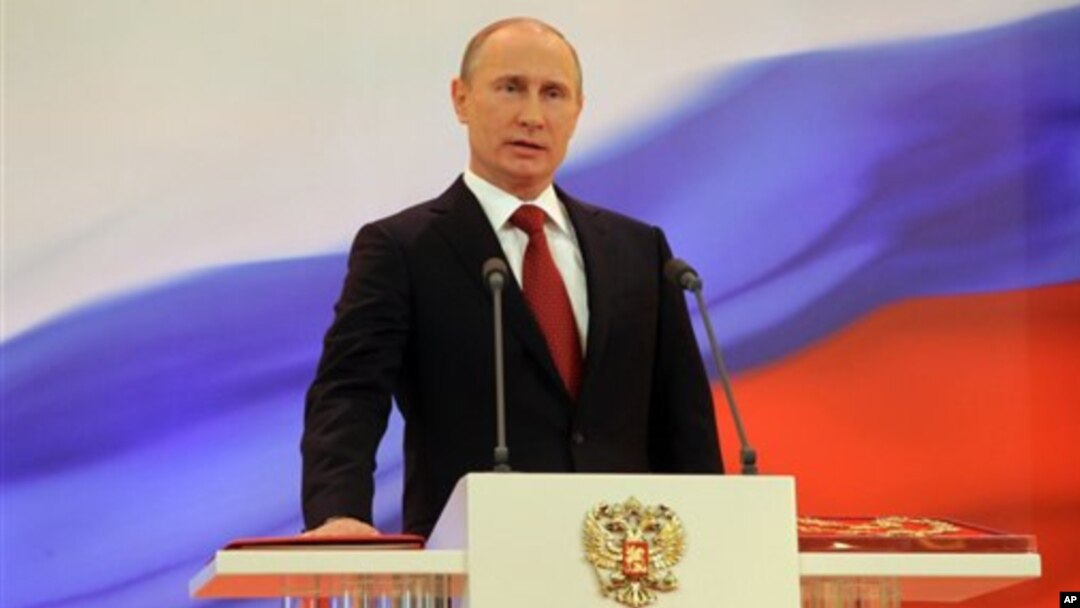 Vladimir Putin meletakkan tangannya di atas konstitusi Rusia saat dilantik kembali sebagai Presiden Rusia untuk masa jabatan yang ketiga di Moskow (7/5).