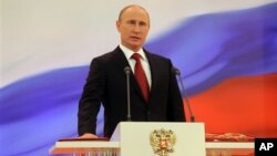 Vladimir Putin meletakkan tangannya di atas konstitusi Rusia saat dilantik kembali sebagai Presiden Rusia untuk masa jabatan yang ketiga di Moskow (7/5).