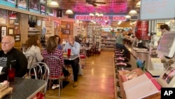 Customers dine at Griffith & Feil Drug on Thursday, March 30, 2023, in Kenova, W. Va. The pharmacy opened in 1892 with a soda fountain counter that was taken out in 1957 but reopened in 2004. (AP Photo/John Raby)