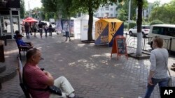 People walk past tents of Ukrainian parties participating in the Parliamentary elections in Kramatorsk, eastern Ukraine, July 18, 2019.