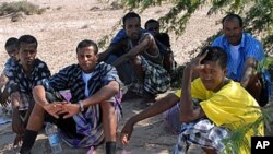 Ethiopian refugees rest in the shade of a desert tree near the southeastern Yemeni town of Ahwar, one day after they reached the Yemeni coast on smugglers boats, October 14, 2008 (file photo)