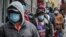 People wait for a distribution of masks and food in the Harlem neighborhood of New York, where the latest analysis shows nearly one-third of those who died from the coronavirus are African American, even though blacks are only about 14% of the population.