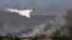 A Canadair firefighting plane sprays water during a fire in Dervenochoria, north-west of Athens, on July 19, 2023.