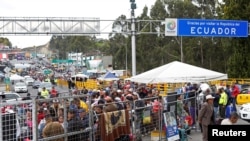 Ciudadanos venezolanos y otros migrantes esperan en la frontera con Colombia, en el puesto de control del puente Rumichaca, en Ecuador, 24 de agosto de 2019.