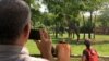 U.S. Air Force Col. Mark Henderson of Mississippi takes video of giraffes at the Nashville Zoo during early stages of the eclipse in Nashville, Tenn., Aug. 21, 2017. 