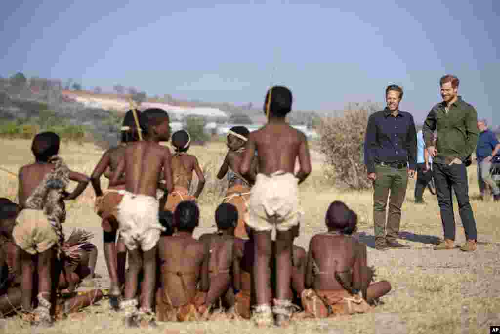 Britain&#39;s Prince Harry, right, and Elephants Without Borders founder Mike Chase are welcomed at a tree planting event with local schoolchildren, at the Chobe Tree Reserve, in Botswana.