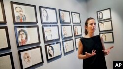 Aurelie Galois speaks with a reporter about her artwork at the French Cultural Center in Boston, June 7, 2016. Every Friday for a year, French artist Galois painted a portrait of a stranger as a way to get acquainted with her adoptive city of Boston.