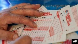 A man fills out a lottery ticket inside a 7-Eleven store in Oakland, Calif., July 26, 2022. The Mega Millions lottery jackpot has topped $1 billion — only the fourth time a lottery game has reached such heights.