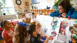 Preschool Executive Director Maria Isabel Ballivian, right, listens to her students on what characters of the TV show PAW Patrol they will vote for as their favorite character at the ACCA Child Development Center in Annandale, Va.