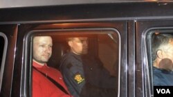 Tersangka pelaku serangan teror, Anders Behring Breivik (kiri) meninggalkan pengadilan di ibukota Oslo dengan pengawalan ketat (25/7).