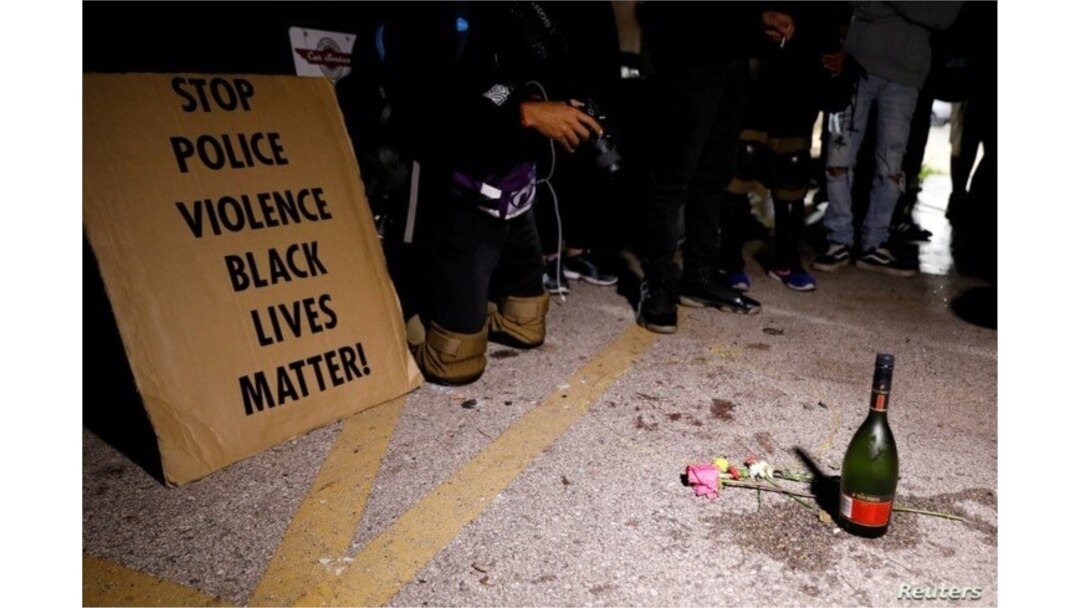 Una pancarta, una botella de alcohol y flores fueron colocadas en homenaje a las víctimas de un tiroteo el martes por la noche durante las protestas por el tiroteo policial de Jacob Blake. Dos personas murieron y una fue herida el martes.