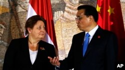 Chinese Premier Li Keqiang (r) speaks with Prime Minister of Latvia Laimdota Straujuma during China - Central and Eastern Europe meeting of heads of government in Belgrade, Serbia, Dec. 16, 2014. 