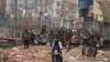 Men ride a motorcycle past security forces patrolling a street in a riot affected area after clashes erupted between people demonstrating for and against a new citizenship law in New Delhi, India.