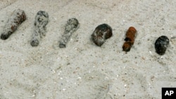 FILE - Some of the more than 1,100 old fuses and small anti-aircraft shells that have been found along the Atlantic Ocean in Surf City, N.J., Feb 10, 2009.