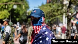 A man dressed in an American flag joins protesters in Portland, Oregon, U.S., Aug. 22, 2020.