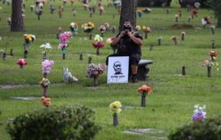 A mourner adjusts his protective face mask as he waits for the funeral for George Floyd at the Houston Memorial Gardens cemetery in Pearland, Texas, June 9, 2020.