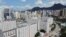Sebuah real estat dengan latar belakang puncak Lion Rock, di Hong Kong, China, 3 Juni 2021. Sebuah perusahaan ekuitas swasta AS, Blackstone, membatalkan rencana pembelian properti China, Soho China, bernilai $3 miliar. (Foto: REUTERS/Joyce Zhou)