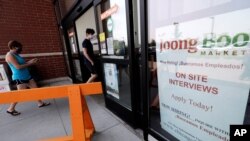 FILE - A hiring sign is displayed at a grocery store in Glenview, Illinois, June 18, 2020. 