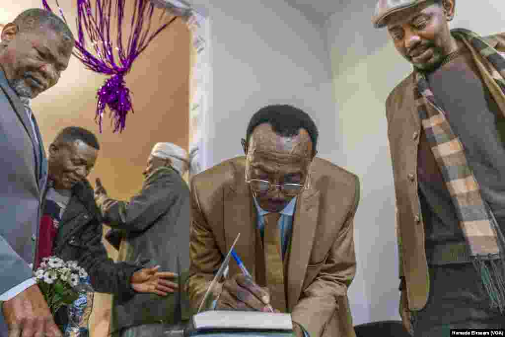 At the Cairo Nights Cafe, Sudanese writer Abdulbaqie Ferren signs copies of his book "African Folk Literature in the Nuba Mountains," a deep dive into the intangible culture and tribal languages of the southern Sudan area, in Cairo on Dec. 13, 2024.