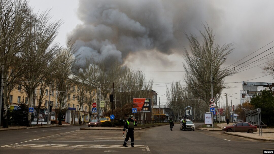 Police officers block a road as smoke rises above buildings following shelling in the course of the Russia-Ukraine war in Donetsk, Russian-controlled Ukraine, on Dec. 21, 2023.