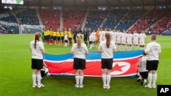 Tim sepakbola putri Korea Utara menyanyikan lagu kebangsaan mereka sebelum pertandingan grup C antara Kolombia melawan Korea Utara yang menandai dimulainya pertandingan Olimpiade Musim Panaas London 2012 di stadion Hampden Park, Glasgow (25/7).