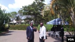 DRC Foreign Minister Raymond Tshibanda (L) and M23 Spokesman Rene Abandi discuss the situation, at DRC peace talks in Kampala, Uganda, Sept. 17. (VOA/A. Hall)