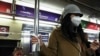 Una mujer con una mascarilla protectora se aferra a un poste del metro con una servilleta en la ciudad de Nueva York, EEUU, el 10 de febrero de 2023. 