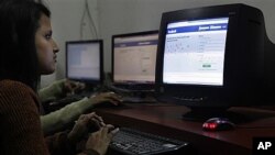 FILE - Young woman surfs Facebook page at an Internet cafe in Gauhati, India, Dec. 6, 2011.