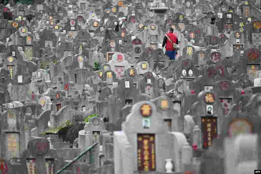 Seorang pria berjalan di antara makam-makam di sebuah pemakaman di Hong Kong, selama &quot;Festival Chung Yeung&quot;, yang juga dikenal sebagai Festival Kesembilan Ganda, di mana orang-orang mengunjungi makam untuk menghormati leluhur mereka. (AFP)&nbsp;