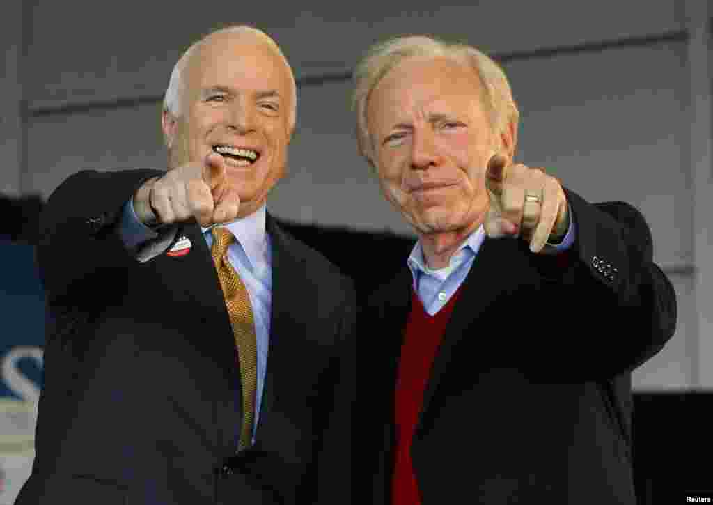U.S. Republican presidential nominee Senator John McCain (R-AZ) (L) and U.S. Senator Joe Lieberman (I-CT) point to a sign in the crowd at a campaign rally in Grand Junction, Colorado, Nov. 4, 2008, the day of the U.S. presidential election.