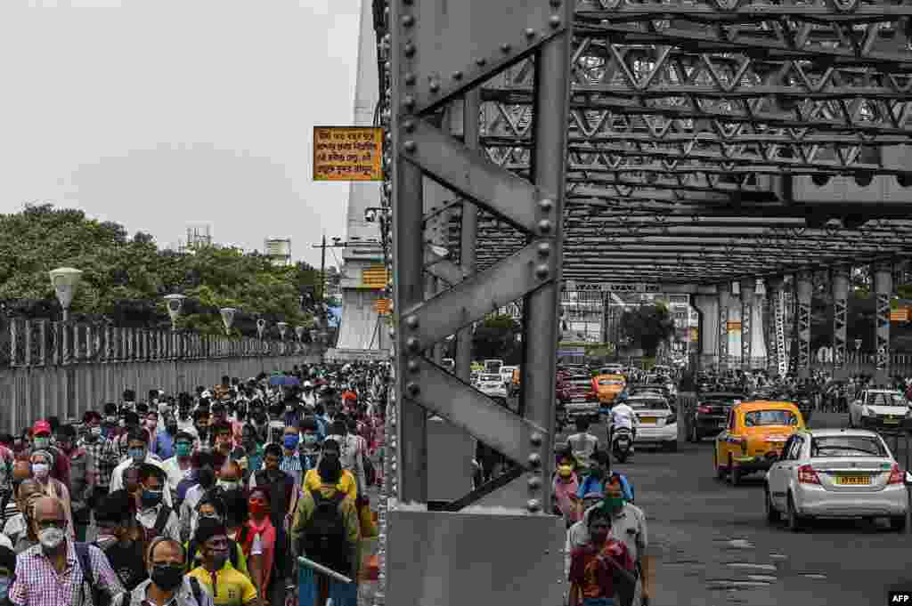 Commuters cross the Howrah Bridge as the state government suspends regular public transport during a lockdown imposed to curb the spread of COVID-19, in Kolkata, India.