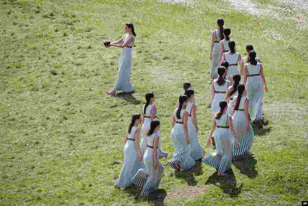 Greek actress Xanthi Georgiou, the High Priestess, carries the flame of the 2020 Tokyo Olympic Games during the dress rehearsal of the flame lighting ceremony at the closed Ancient Olympia site, in southern Greece.