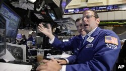 Michael Pistillo (R) works with a fellow specialist on the floor of the New York Stock Exchange, August 9, 2011