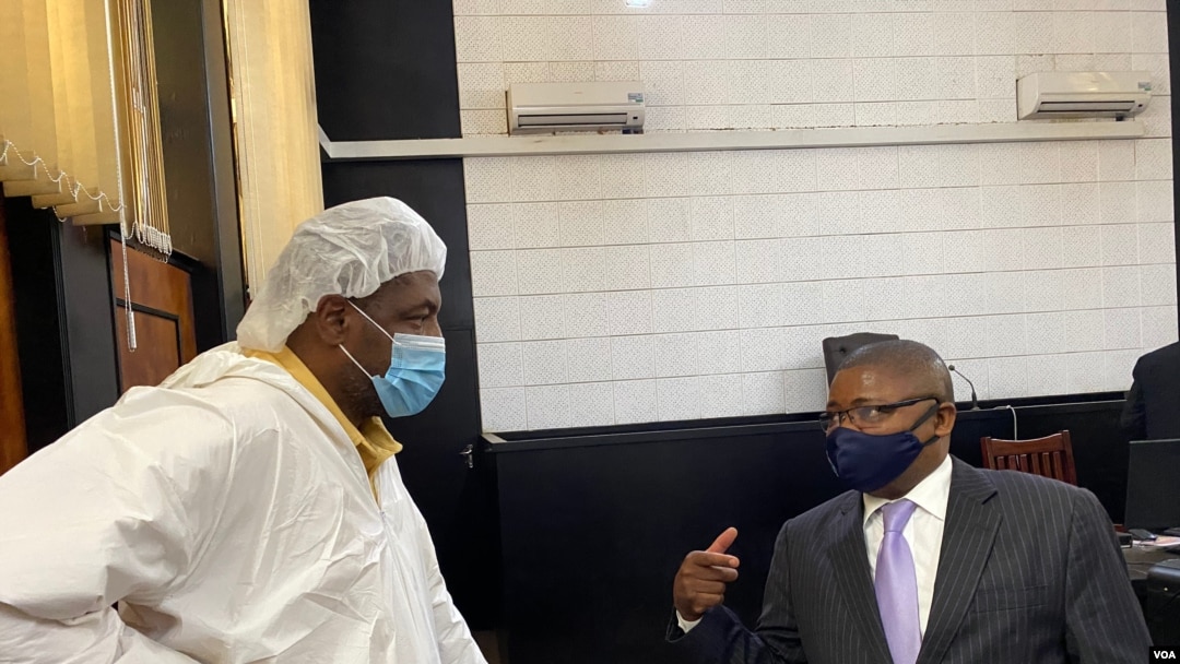 Journalist Hopewell Chin'ono talks to Harrison Nkomo of Zimbabwe Lawyers for Human Rights, in the courthouse at Harare Magistrate’s Court, Jan. 9, 2021. (Columbus Mavhunga/VOA)