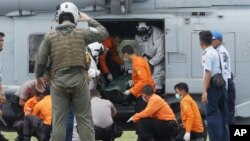 Awak angkatan laut Amerika dari USS Sampson menurunkan jenazah seorang korban pesawat AirAsia dari helikopter di bandara Pangkalan Bun, Jumat (2/1).