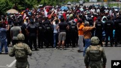 FILE - Mexican authorities stop a group of migrants who had earlier crossed the Mexico-Guatemala border, near Metapa, Chiapas state, Mexico, June 5, 2019. 