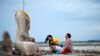 A family prays near the ruins of a headless Buddha statue, which has resurfaced in a dried-up dam due to drought, in Lopburi, Thailand.