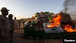 A soldier torches a pile of narcotics during a joint destruction ceremony by the Anti Narcotics Force (ANF) and Pakistan Coast Guards (PCG) on the outskirts of Karachi, Oct. 15, 2015.