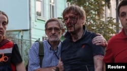 An injured man walks with paramedics after he was rescued from a residential building damaged during a Russian drone and missile strike in Lviv, Ukraine Sept. 4, 2024.