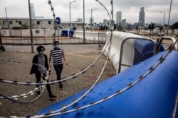 People walk past extra barricades that have been erected near the Legislative Council in Hong Kong on May 26, 2020, ahead of planned protests.