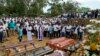 FILE - A priest conducts religious rituals during a mass burial for Easter Sunday bomb blast victims in Negombo, Sri Lanka, April 24, 2019.