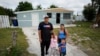 Alexis Llanos, izquierda, su pareja, Diomaris Barboza, y sus hijos Alexa, de 7 años, y Alexis, de 3, afuera de la casa a la que se mudaron en octubre de 2023, en Lehigh Acres, Florida, 27 de diciembre de 2023. (Foto AP/Rebecca Blackwell)