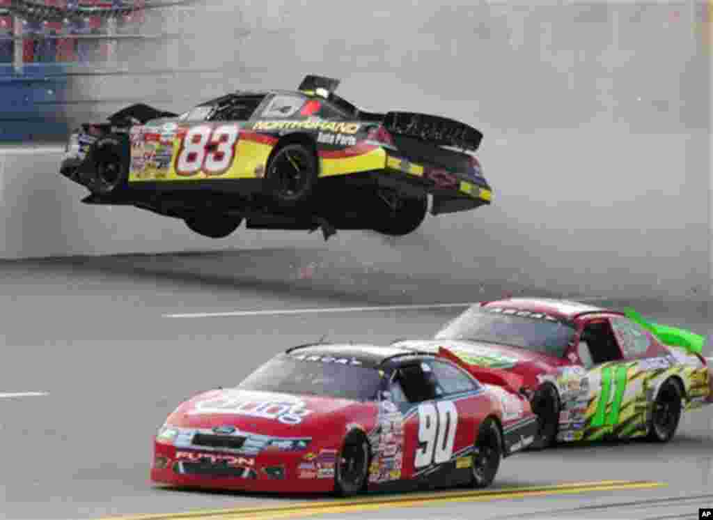 Zach Ralston (90) and Brett Hudson (11) drive past the flipping car of Mike Affarano (83) during the International Motorsports Hall of Fame 250 ARCA auto race at the Talladega Superspeedway in Talladega, Ala., Friday, May 4, 2012. (AP Photo/Dave Martin)