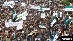 Demonstrators protesting against Syria's President Bashar al-Assad march through the streets after Friday prayers in Hula, near Homs, October 28, 2011.