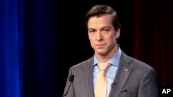 El libertario Chase Oliver, candidato por Georgia al Senado federal, escucha durante un debate, el 16 de octubre de 2022, en Atlanta. 
