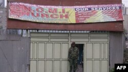 Солдат кенийских военизированных формирований охраняет вход в церковь, где прогремел взрыв. Найроби, Кения